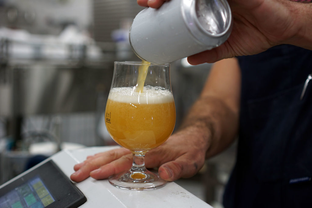 Tasting a can of beer during a packaging day at the Beerbliotek Brewery.