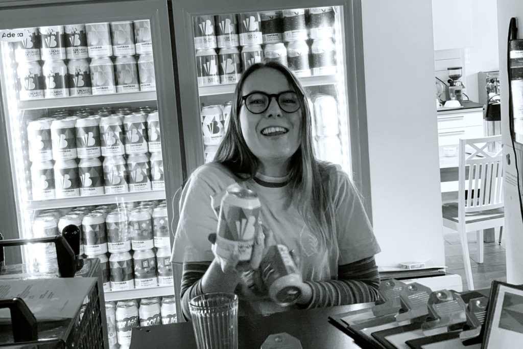 Madison Simpson holding some cans in the Beerbliotek Tap Room.