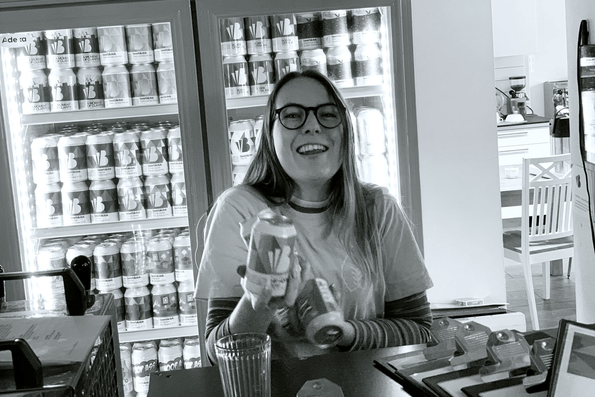 Madison Simpson holding some cans in the Beerbliotek Tap Room.